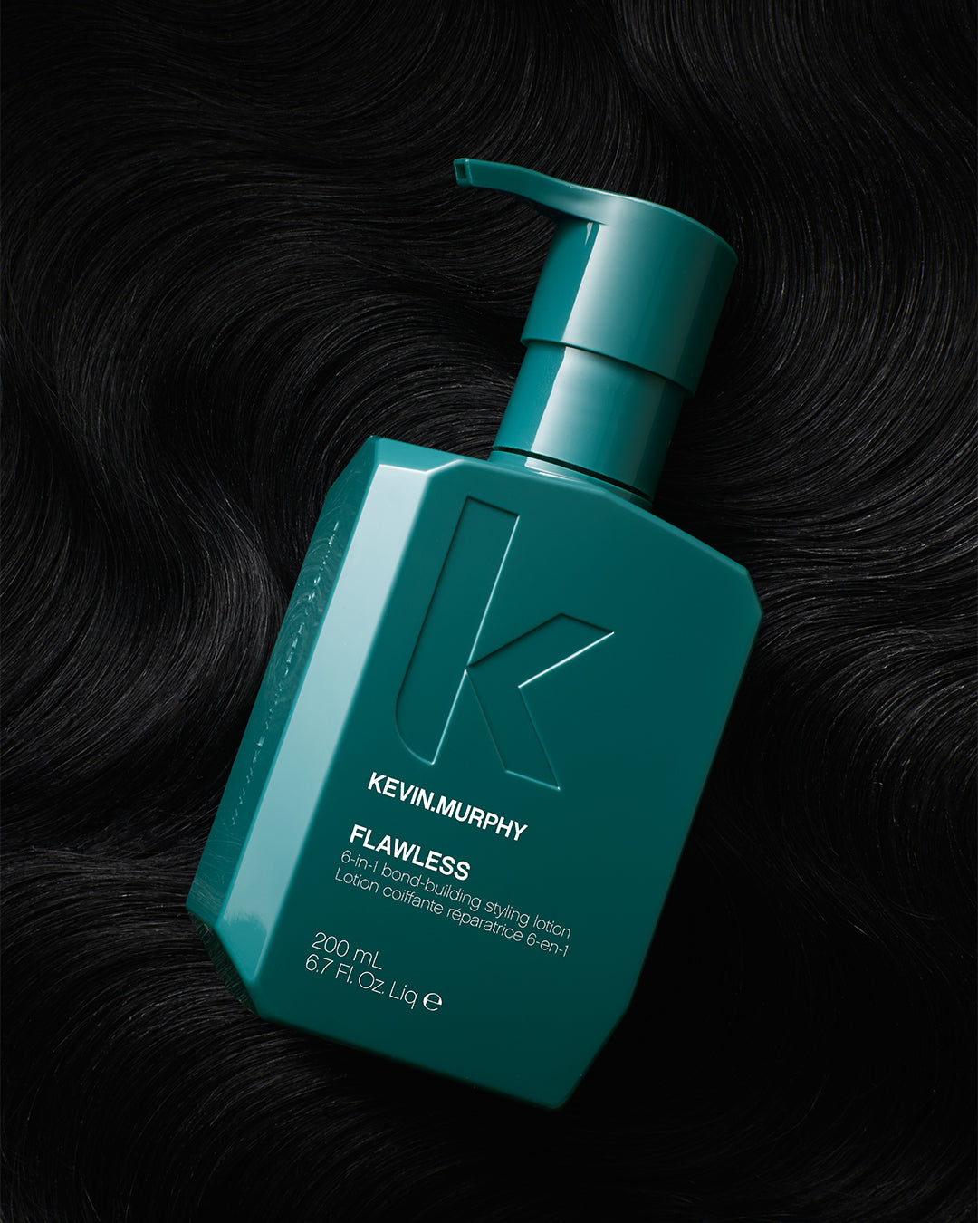 
                  
                    KEVIN.MURPHY FLAWLESS 6-in-1 bond-building stylinglotion 200ml – teal pompfles op een achtergrond van donker golvend haar
                  
                